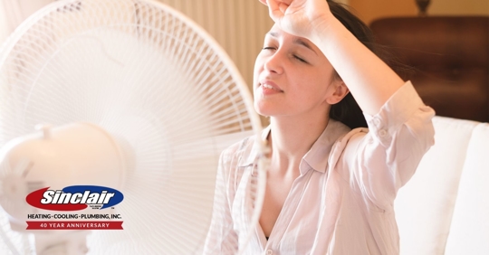 Woman cooling off in front of large fan.