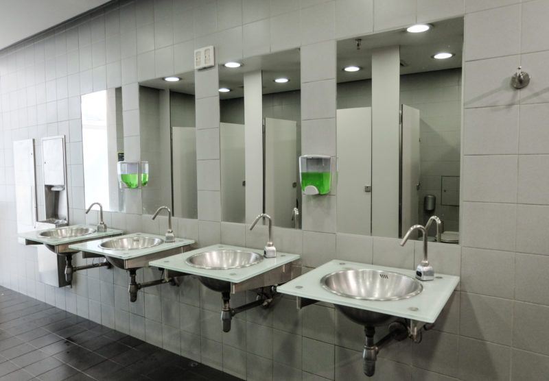 Four metal sinks in a commercial building in Lubbock