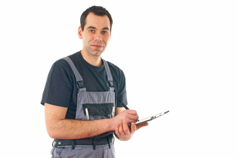 A Lubbock HVAC technician taking notes on a clipboard