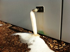 A pipe with frozen water coming out of it