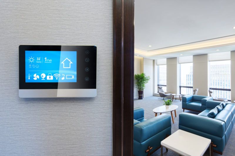 A smart thermostat on a gray wall